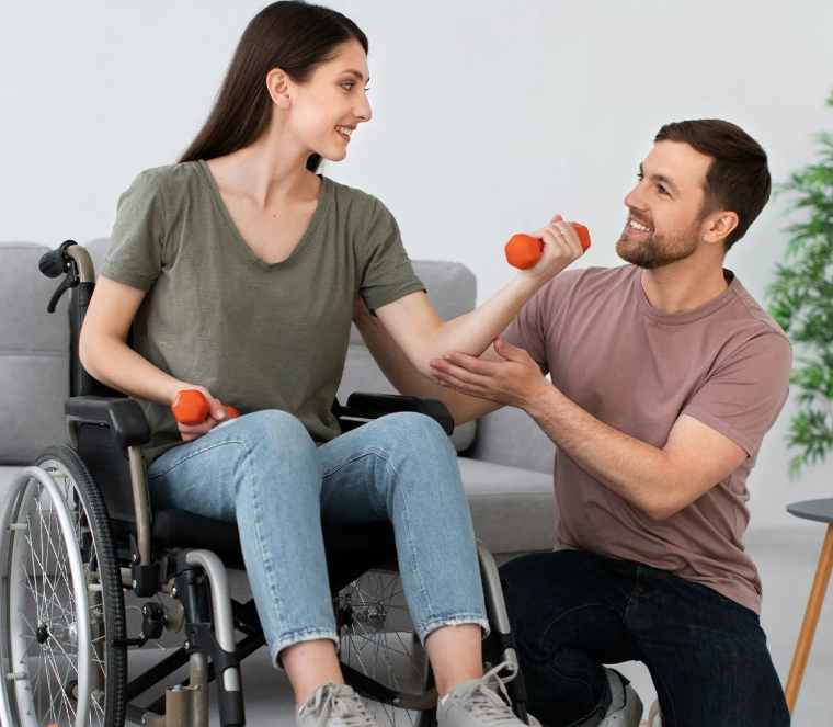 A woman in a wheelchair working out with a trainer.