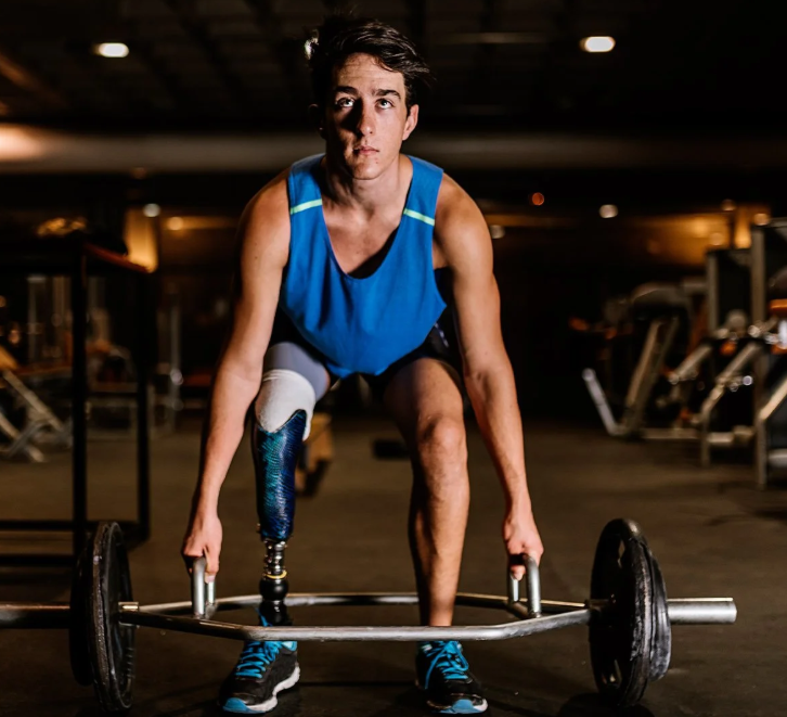 A man with a prosthetic leg working out in a gym.